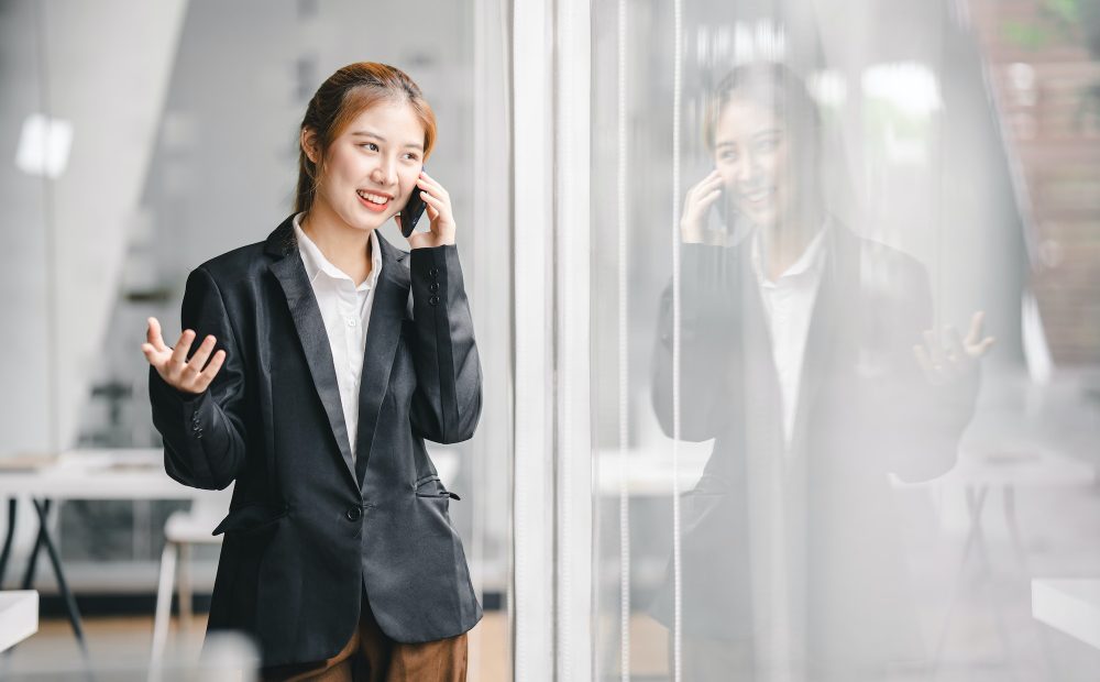 Asian female worker talking on the phone at the office